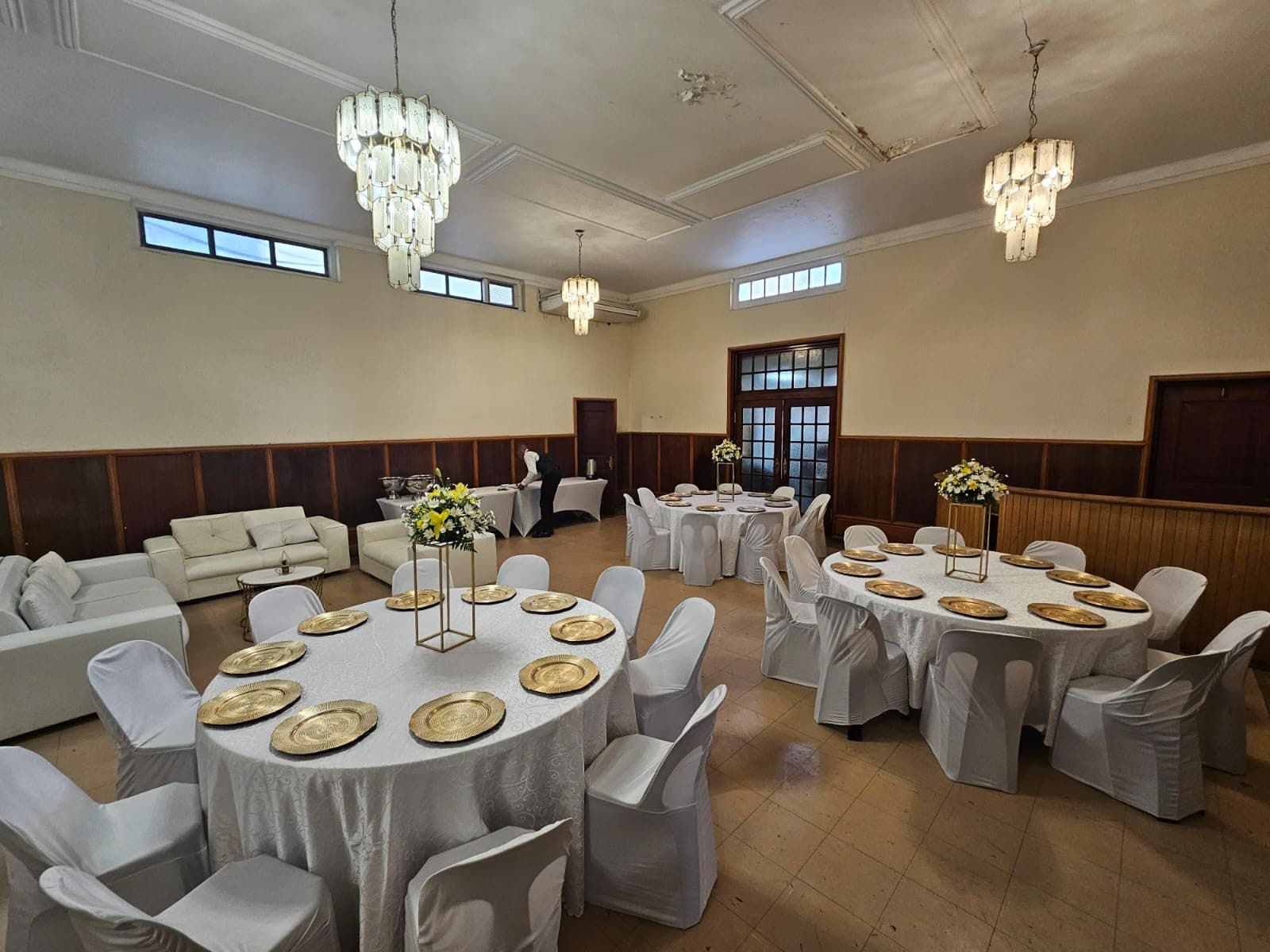 Ballroom with chandeliers and round tables in white styling
